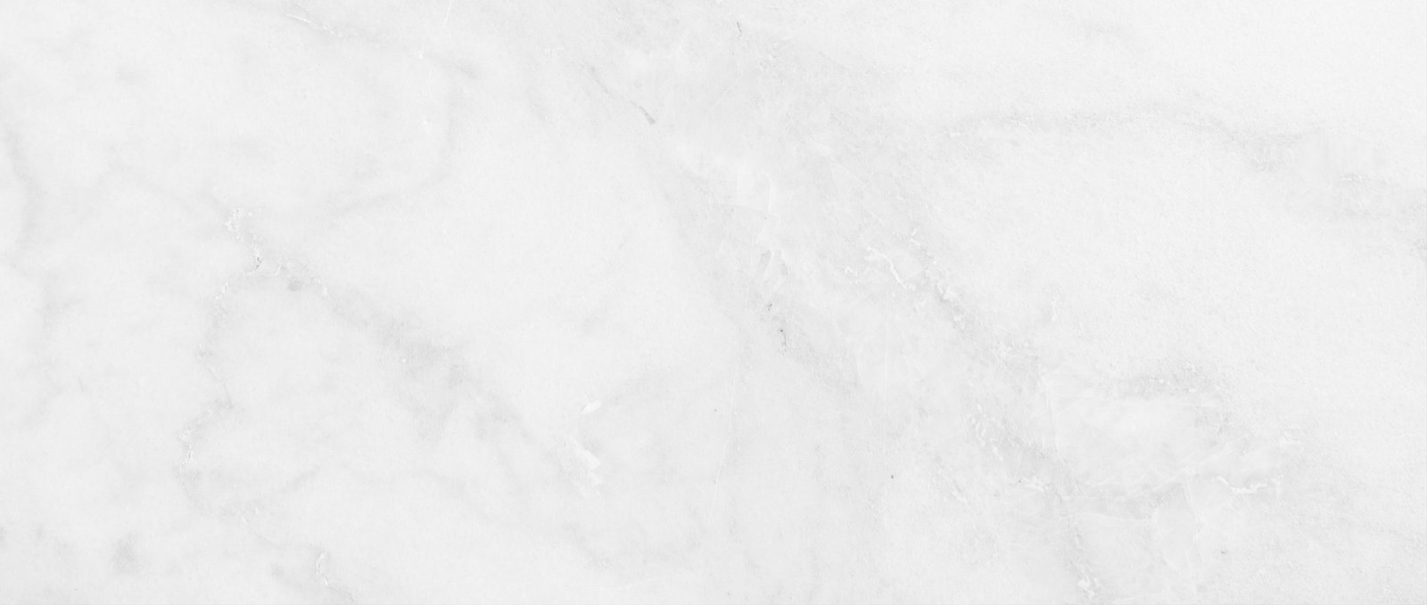 Close-up of Carrara marble stone texture with intricate grey veining on a white background.