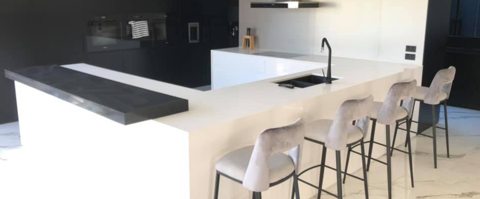 Modern black and white kitchen with a newly installed Caesarstone benchtop island.