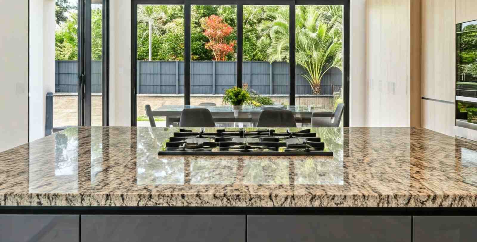 Modern kitchen with a large granite countertop and a gas stove.