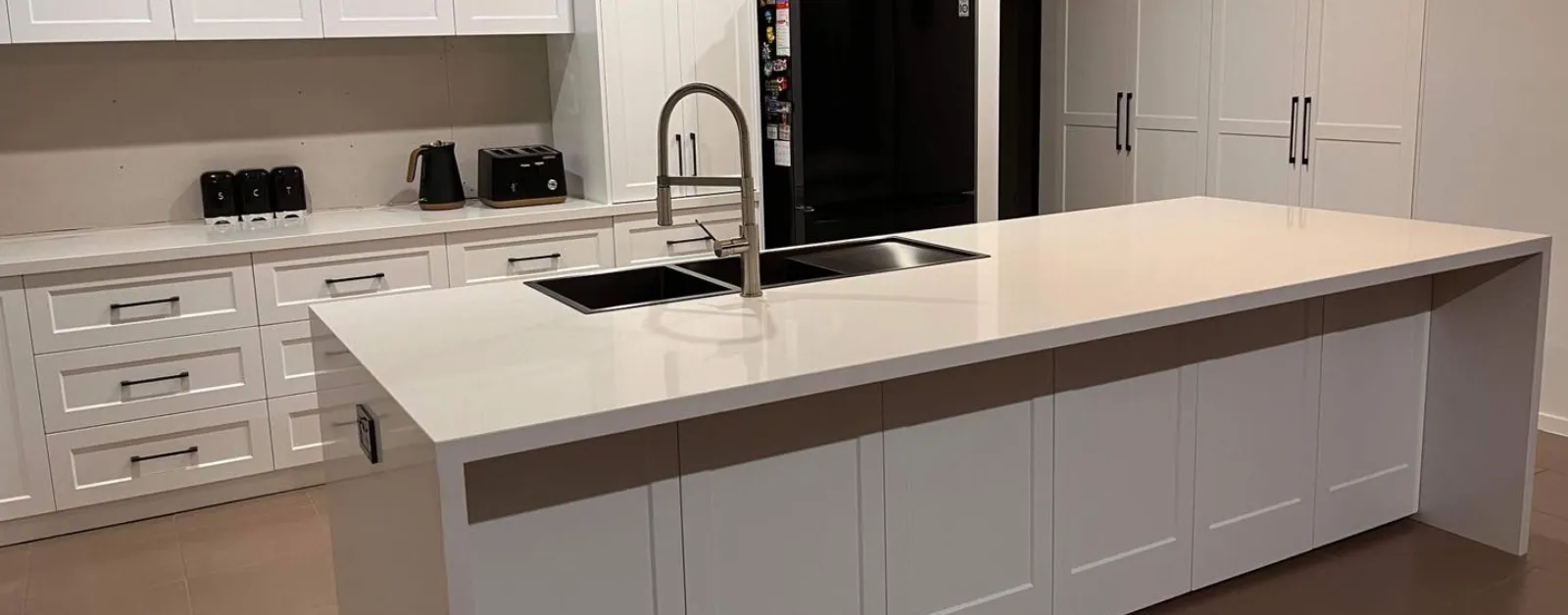 Spacious kitchen featuring a large white quartzite island countertop