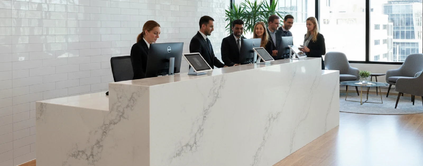 Modern office reception area featuring a large reception desk with a white marble-like texture YDL Stone.