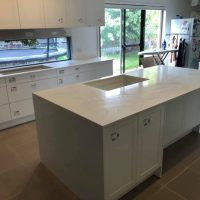 Spacious kitchen with a large island, white cabinetry, and Kalala Bianco YDL Stone accents throughout.
